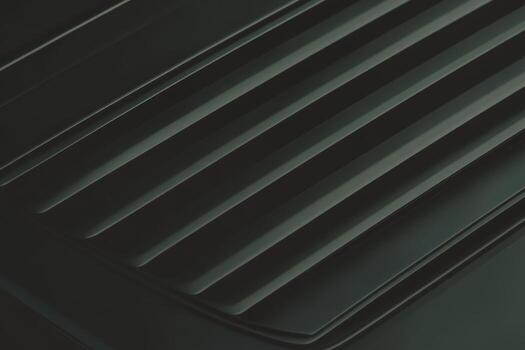 Textured black surface with parallel lines and grooves creating depth photo