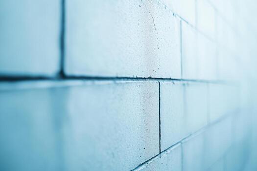 Close-up view of textured concrete wall in soft blue light during daylight photo