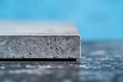 Detailed view of a concrete slab on a textured surface with blue background photo