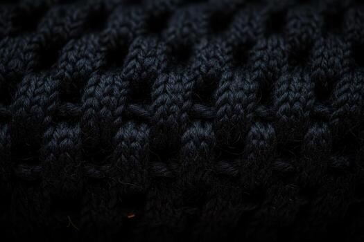 Detailed close-up of a textured black knit fabric showing intricate patterns photo