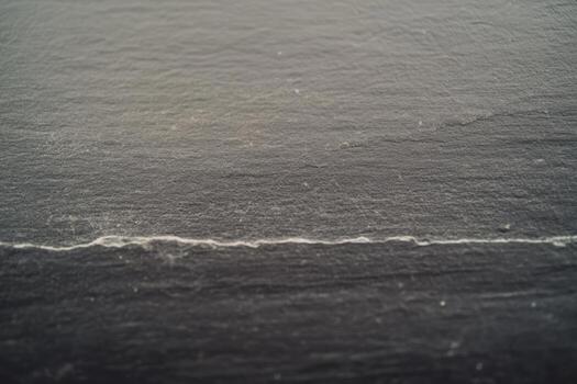 Surface texture revealing subtle lines and patterns on dark stone photo