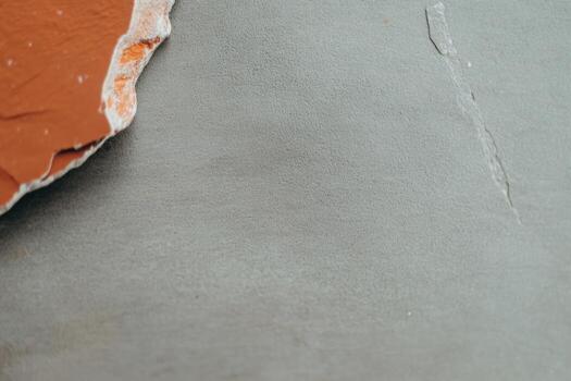 Textured surface with paint remnants and smooth gray backdrop in indoor setting photo