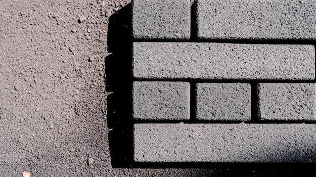 Dark-colored paving bricks arranged on a textured surface photo