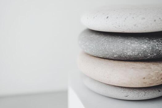Stacked smooth stones in neutral colors on a clean surface photo