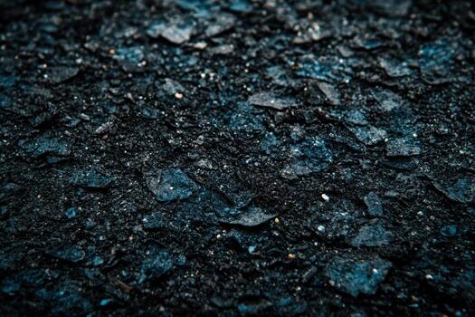 Close-up view of textured asphalt surface with dark hues and rough edges photo