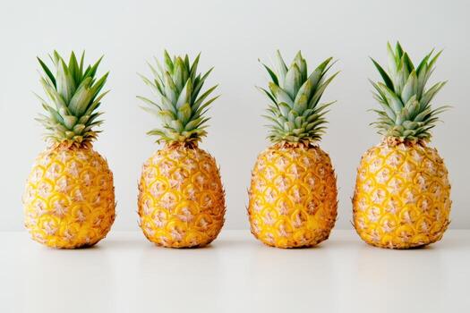 Pineapples lined up on a clean surface with simple background design photo