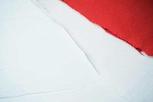 Fabric swatches of red and white textiles on a textured surface photo