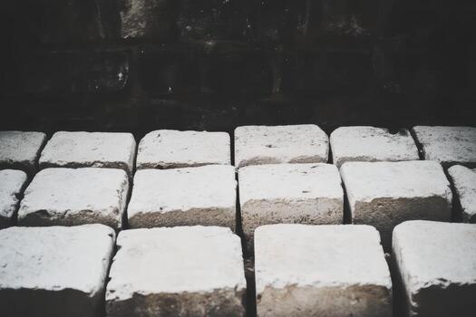 Concrete blocks arranged in neat rows against a textured dark background photo