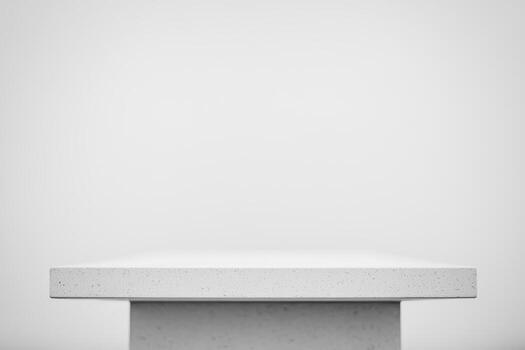 Minimalist white table set against a blank wall in empty space photo