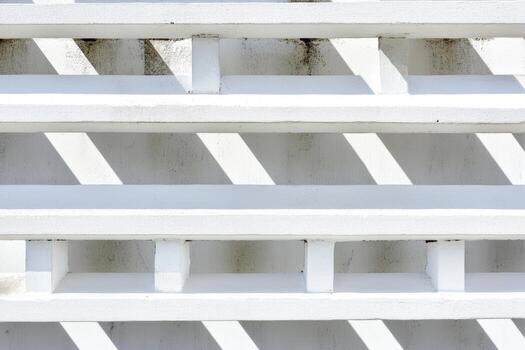 Abstract patterns of shadows and light on a white wall during the day photo