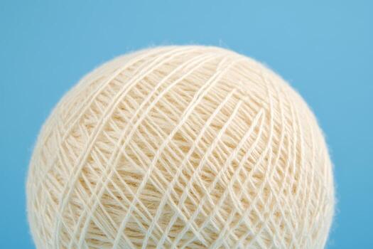 Wool yarn ball on a light blue background showcasing crafting potential photo