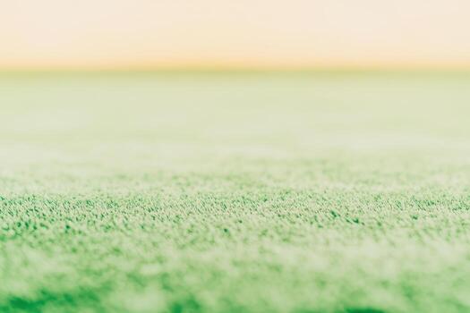 Vibrant green carpet texture with a soft gradient background at sunset photo