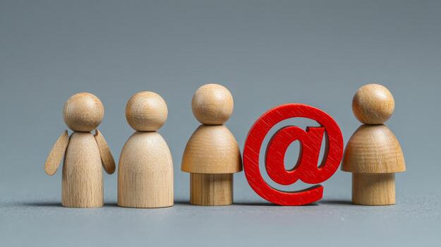 Four wooden figures standing in a row with a red symbol between the third and fourth figures photo