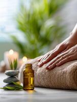 relajante spa escena con esencial petróleo botella, equilibrado piedras, iluminado velas, y manos descansando en un suave toalla para calmante bienestar y aromaterapia terapia sesión foto
