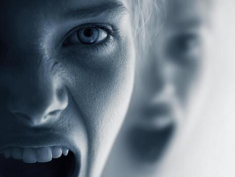Intense emotional expression with fearsome emotions captured in a dramatic composition showing a person with fangs and another blurred figure shouting in the background photo