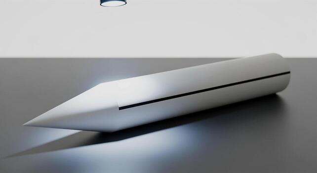 Sleek Silver Object with Sharp Point on Gray Surface. photo