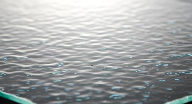 Close-up of rippling water surface with soft reflections, creating a serene and abstract background. photo