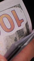 Vertikale Hände Zählen einer hundert Dollar Rechnungen auf schwarz Hintergrund video