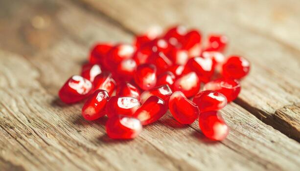 Glistening Ruby Red Pomegranate Jewels on a Rustic Weathered Wood Surface. photo