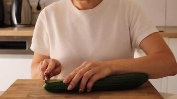 In this engaging tutorial, a woman prepares sushi using fresh ingredients right at home. She skillfully slices cucumbers and organizes her workspace to create delicious rolls video