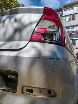 Car rear end with missing light and visible damaged parts of automobile exterior. photo