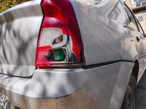 Broken red rear car light with cracked surface and exposed inner automobile parts. photo
