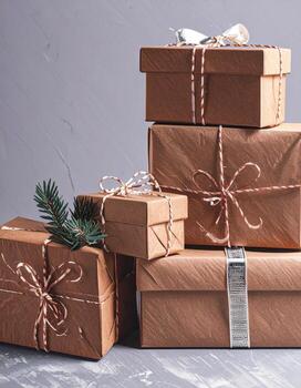 Stack of Brown Wrapped Presents with String on Gray Textured Surface photo