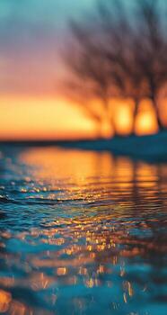 un puesta de sol con agua y arboles en el antecedentes foto