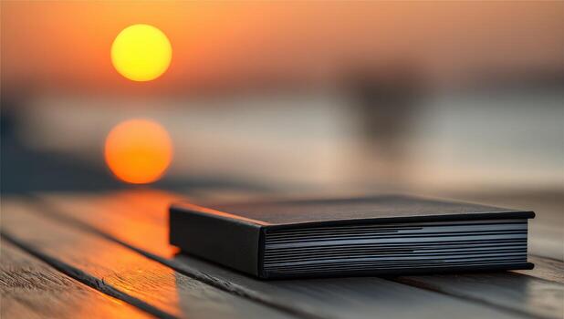 A book sitting on a wooden table with the sun in the background photo
