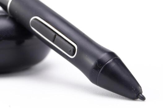 Close-up of a black digital pen with two buttons on a white surface, showcasing its design and functionality. photo