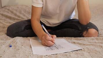 uma mulher envolve dentro uma relaxante atividade Como ela diligentemente resolve uma sudoku enigma em uma bloco de anotações. você pode Vejo dela profundo concentração e a acolhedor ambiente do dela arredores video