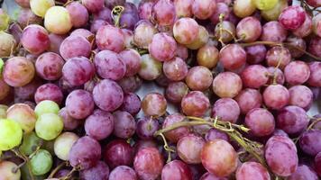 A close-up shot of fresh red and green grapes, creating a colorful texture and background video