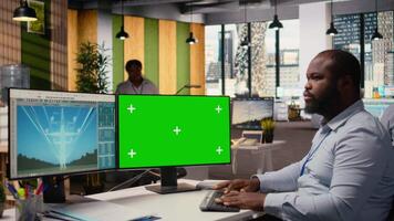 Technician works on power line tower CAD design on green screen PC in office. RD department worker uses program on chroma key computer to optimize transmission tower systems, camera A video