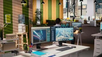 arbetstagare går in kontor, användningar elektrisk rutnät och vind bruka layout optimering verktyg till förbättra rena energi system. tekniker börjar arbete på kraft rader och trogen vind turbin simulering, kamera en video