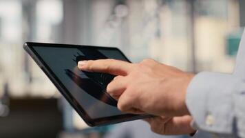 Close up of researcher analyzing turbine component on tablet to maximize sustainability. CAD designer uses app on device to refine blade aerodynamics, boosting clean energy output, camera B video
