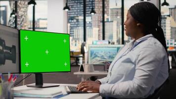 Wind energy researcher analyzes turbine component on green screen PC to maximize sustainability. CAD designer uses software on mockup computer to boost turbine clean energy output, camera B video