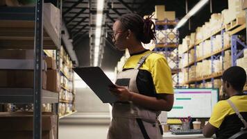 e-handel kvinna anställd kontroll paket detaljer på urklipp, bearbetning order för sändning bearbeta. övervaka frakt lager och alstrande etiketter för stor skala aktivitet. kamera a. video