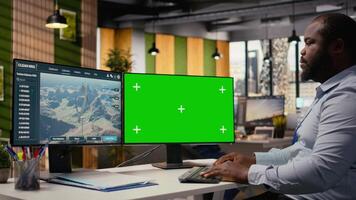 Technician working on futuristic wind turbine concept on isolated screen PC designed for clean energy output. Man in office uses chroma key computer to research cutting edge VAWT innovation, camera A video