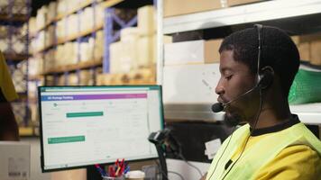 Male call center clerk assisting a person with order mix up problems, verifying parcel status on package tracking software in the warehouse facility. Customer service dispatch support. Camera A. video