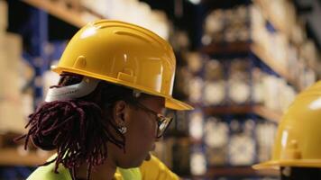 afrikansk amerikan arbetare ser till paket status på en paket spårning programvara på pc, arbetssätt i industriell depå för importera exportera operationer. hantera lager och avsändande protokoll. kamera b. video