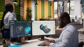 ingeniero en oficina trabajando en viento turbina componente canalla diseño, haciendo eco simpático energía investigación. empleado haciendo digital modelado de viento energía generador parte utilizando ordenador personal programa, cámara un video