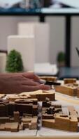 vertical fechar acima do urbano desenvolvedores mostrando mestre plano para residencial disposição projeto, usando 3d modelos em mesa para presente idéia do uma inteligente cidade. local preparação para a infraestrutura crescimento. Câmera uma. video