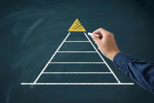 Hand drawing a pyramid chart on a chalkboard, symbolizing growth, strategy, and hierarchical structure in business planning photo