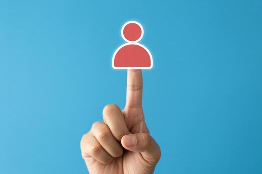 Hand selecting a digital profile icon on a touchscreen against a blue background, symbolizing online identity and user selection photo