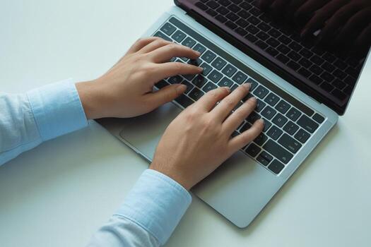 Person typing on laptop computer keyboard, working from home office, productivity and efficiency concept Close-up view of hands on a silver laptop keyboard photo