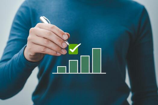 Person drawing rising bar chart with check mark, signifying growth and success A visual representation of achieving goals and positive progress in bus photo