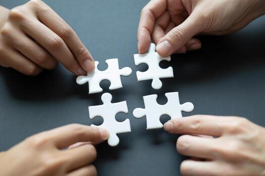 Teamwork Hands Connecting Jigsaw Puzzle Pieces on a Desk, Symbolizing Collaboration and Problem-Solving photo