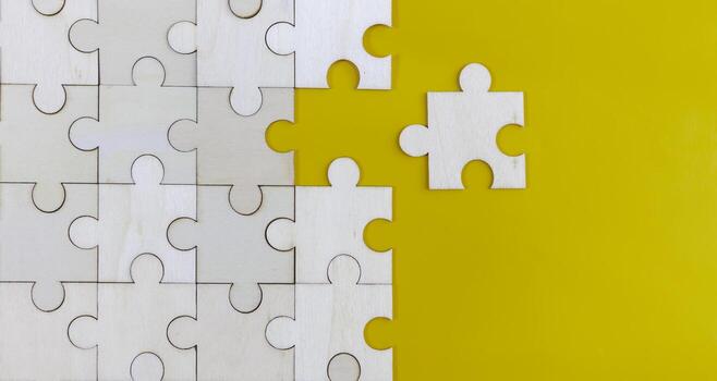 White puzzle on yellow background with copy space. Business strategy teamwork or problem solving concept. photo