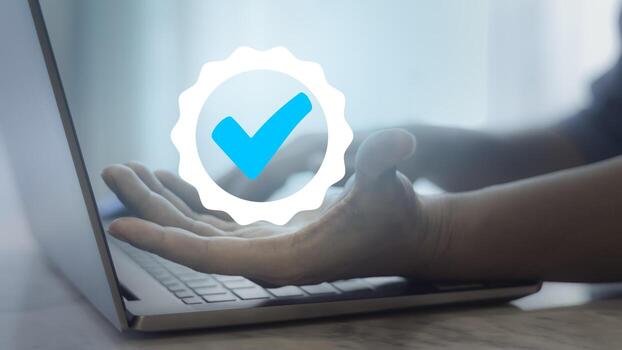 Man using laptop and showing the sign of the top service. Concept of quality assurance, guarantee, standards, ISO certification and standardization. photo