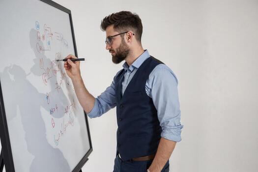 Professional man writing ideas on a whiteboard in a modern office environment during a brainstorming session photo